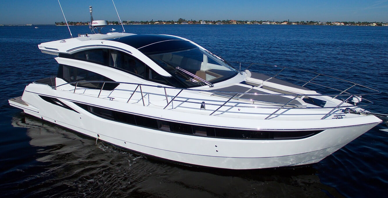 The starboard bow of the Galeon 430 HTC yacht with a white exterior and rails at the bow