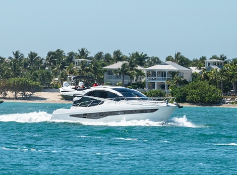 Galeon yacht cruising the waters with waterfront homes in the background