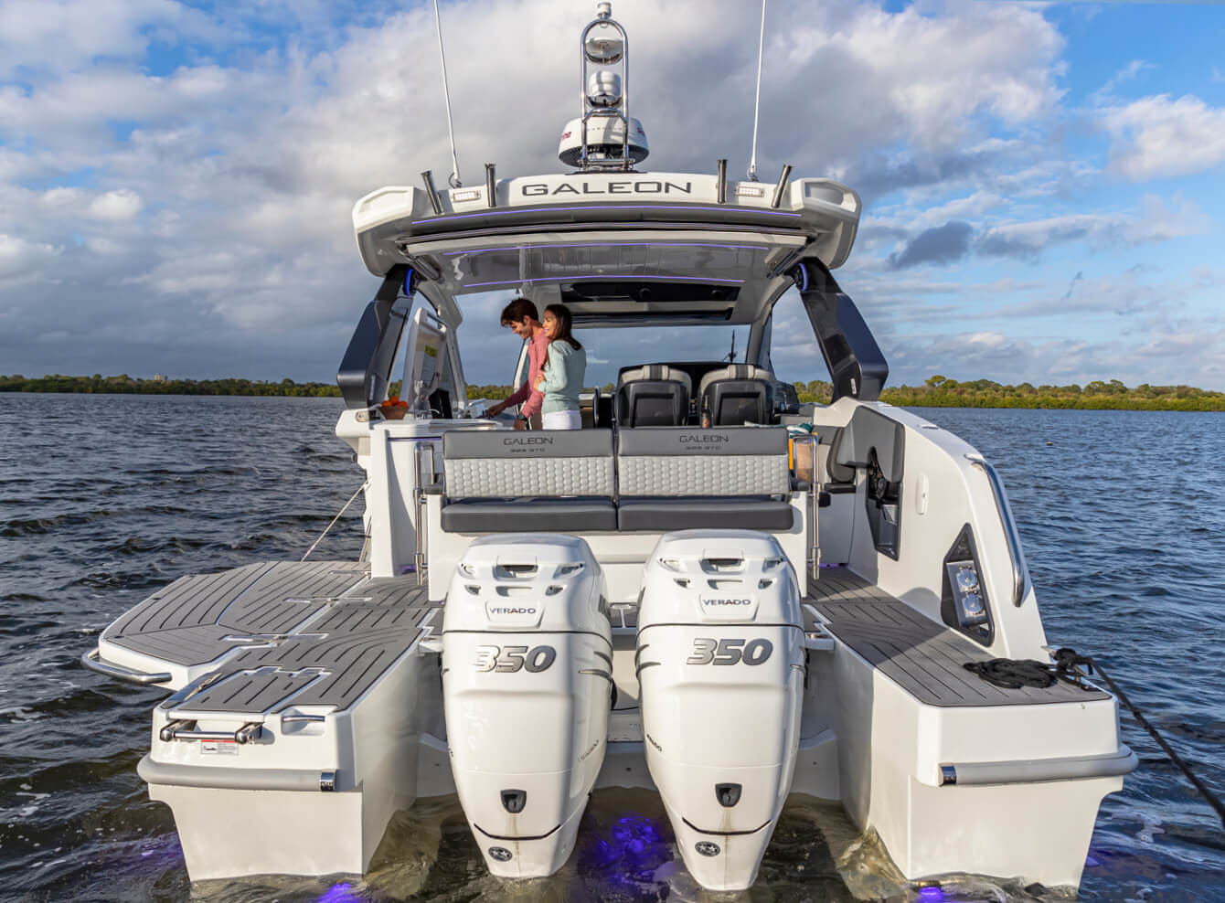 Stern view of the 325 GTO with dual engines and man and woman onboard