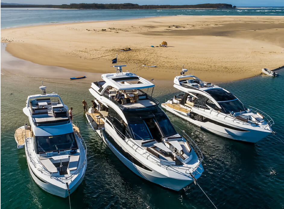 Three Galeon yachts anchored on the shore of a sandy island 