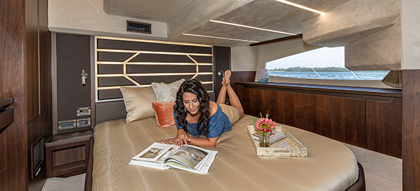 Woman laying on the bed, reading journal on Galeon Yacht