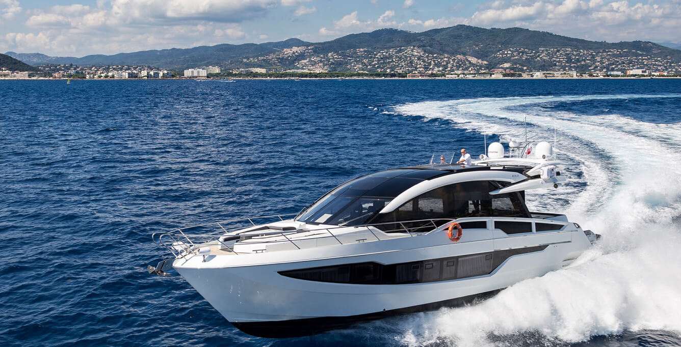Galeon yacht cruising and making a right turn with a small mountain behind it