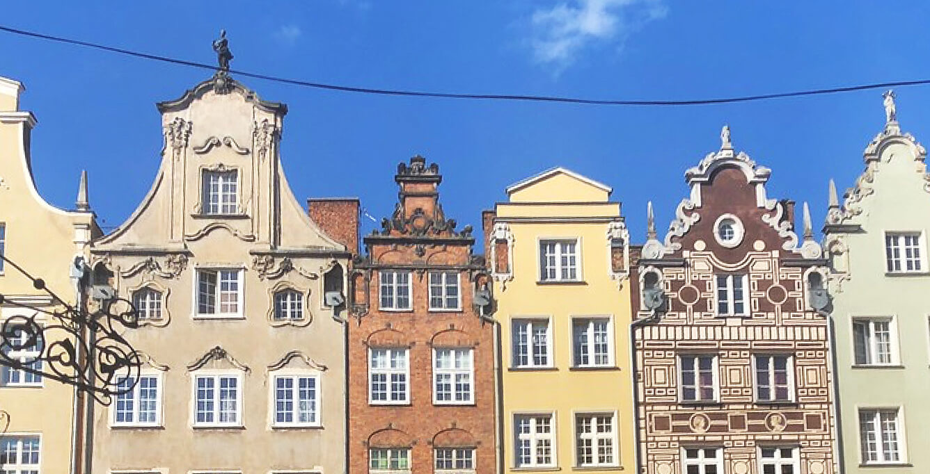 Tall, colorful townhomes with a blue sky and a powerline