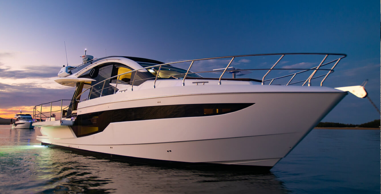 The bow and railings on a Galeon yacht at sunset with its rear LED lights on