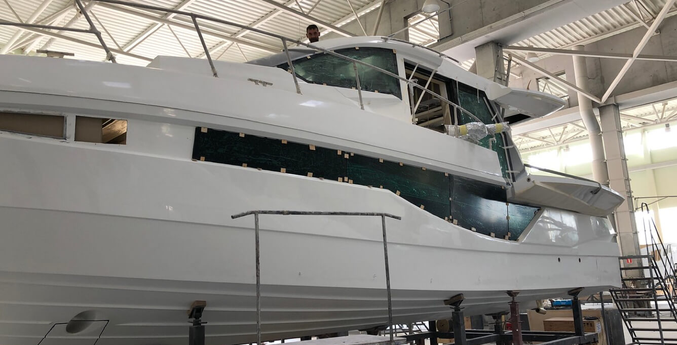 The exterior of a Galeon yacht during production and a person on the top deck
