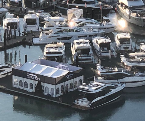A number of Galeon yachts parked in a marina with a white covering over part of the dock