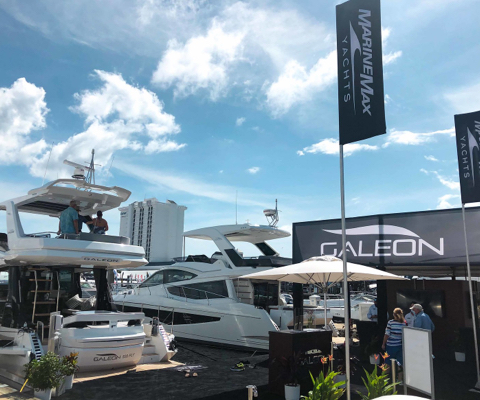 The sterns of two Galeon yachts next to a Galeon tent in a marina