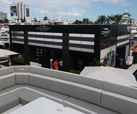 Spacious yacht deck overlooks a bustling Fort Lauderdale International Boat Show with a Galeon Yachts pavilion.