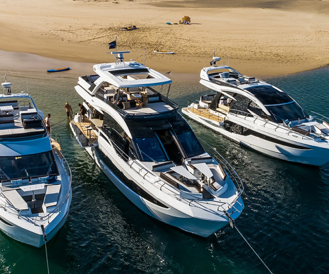 Three Galeon yachts anchored next to each other in front of a sand bar
