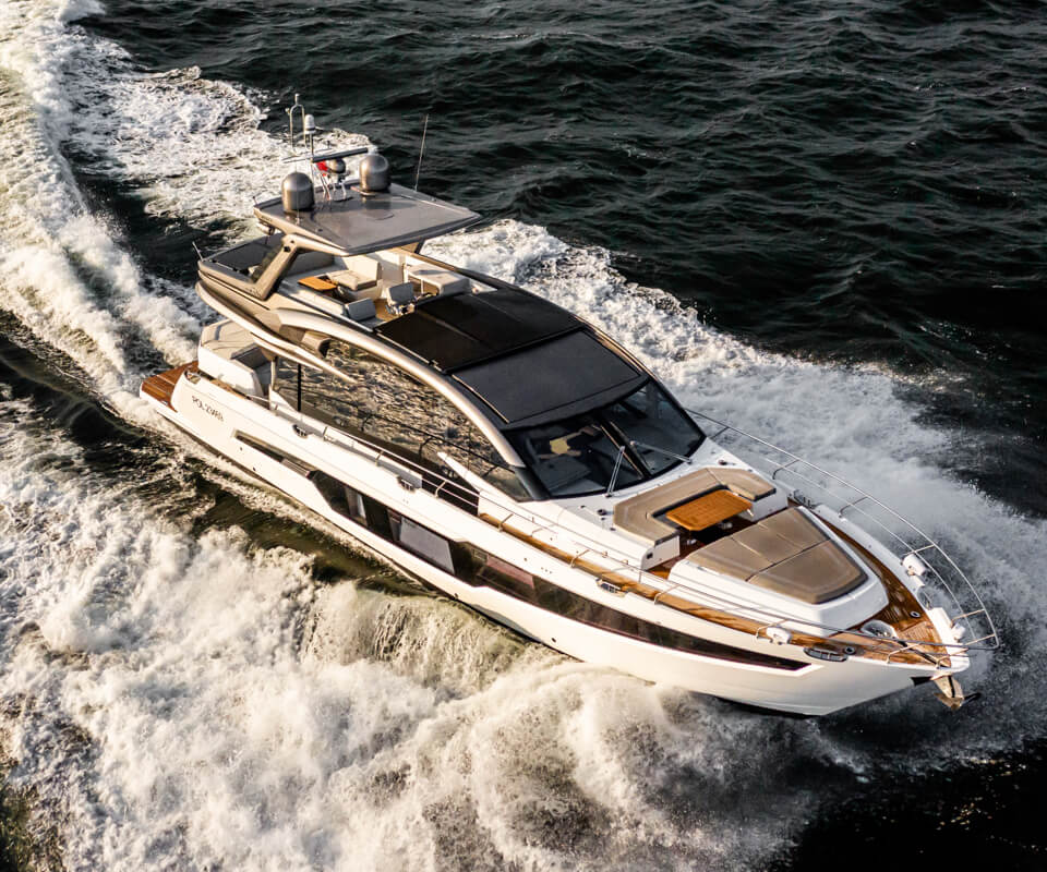 Bird's eye view of a Galeon yacht with a wooden deck and a wake splashing on either side